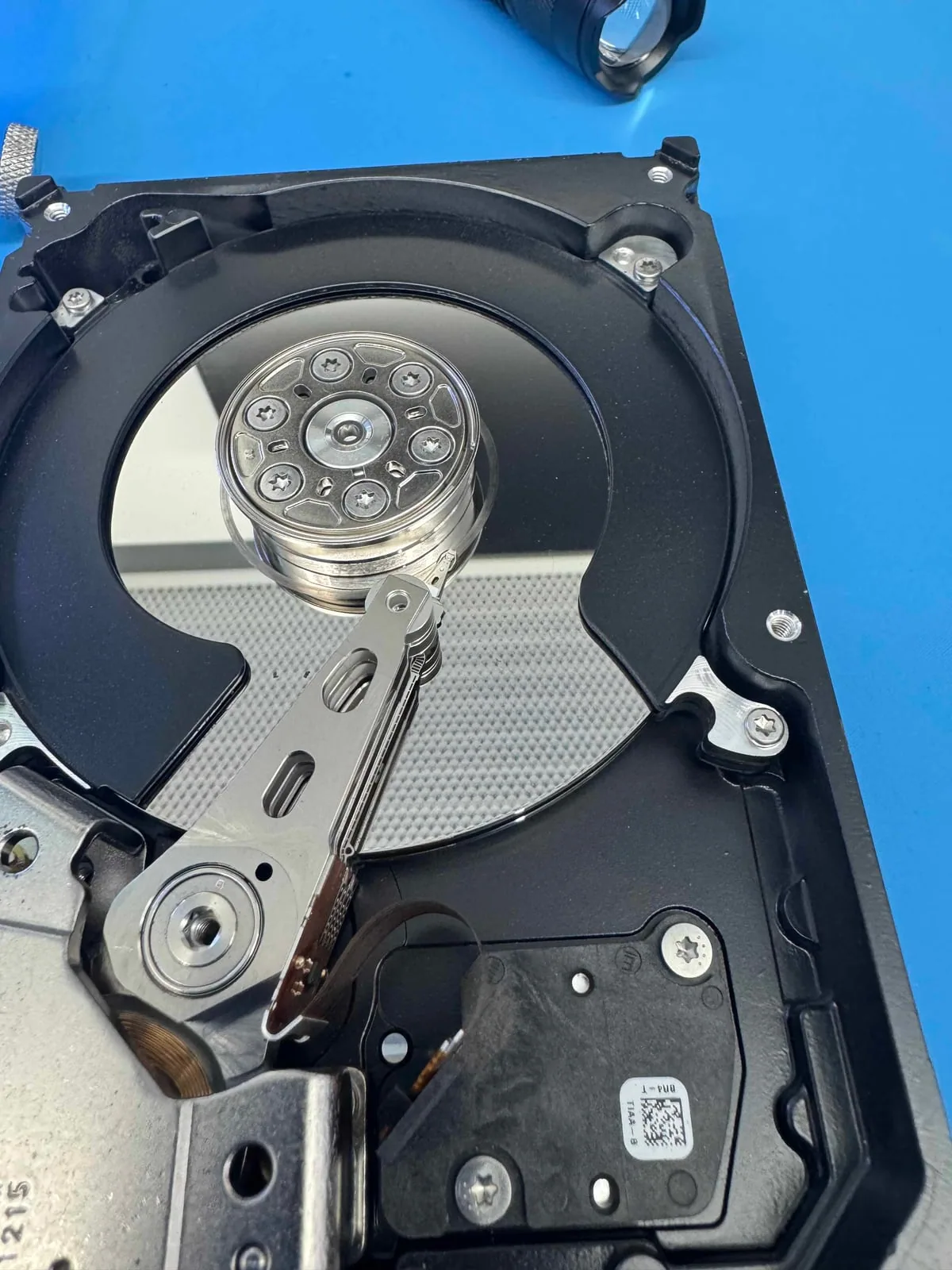Open hard drive prepared for controlled inspection on a clean workbench