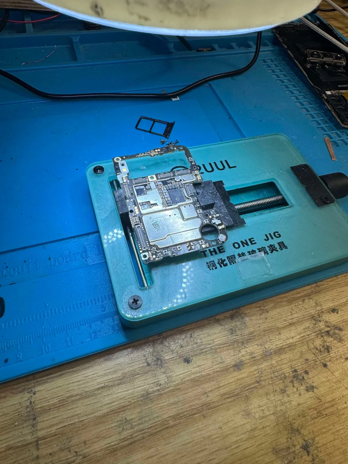 Phone logic board secured for microscope-assisted board-level repair and data recovery