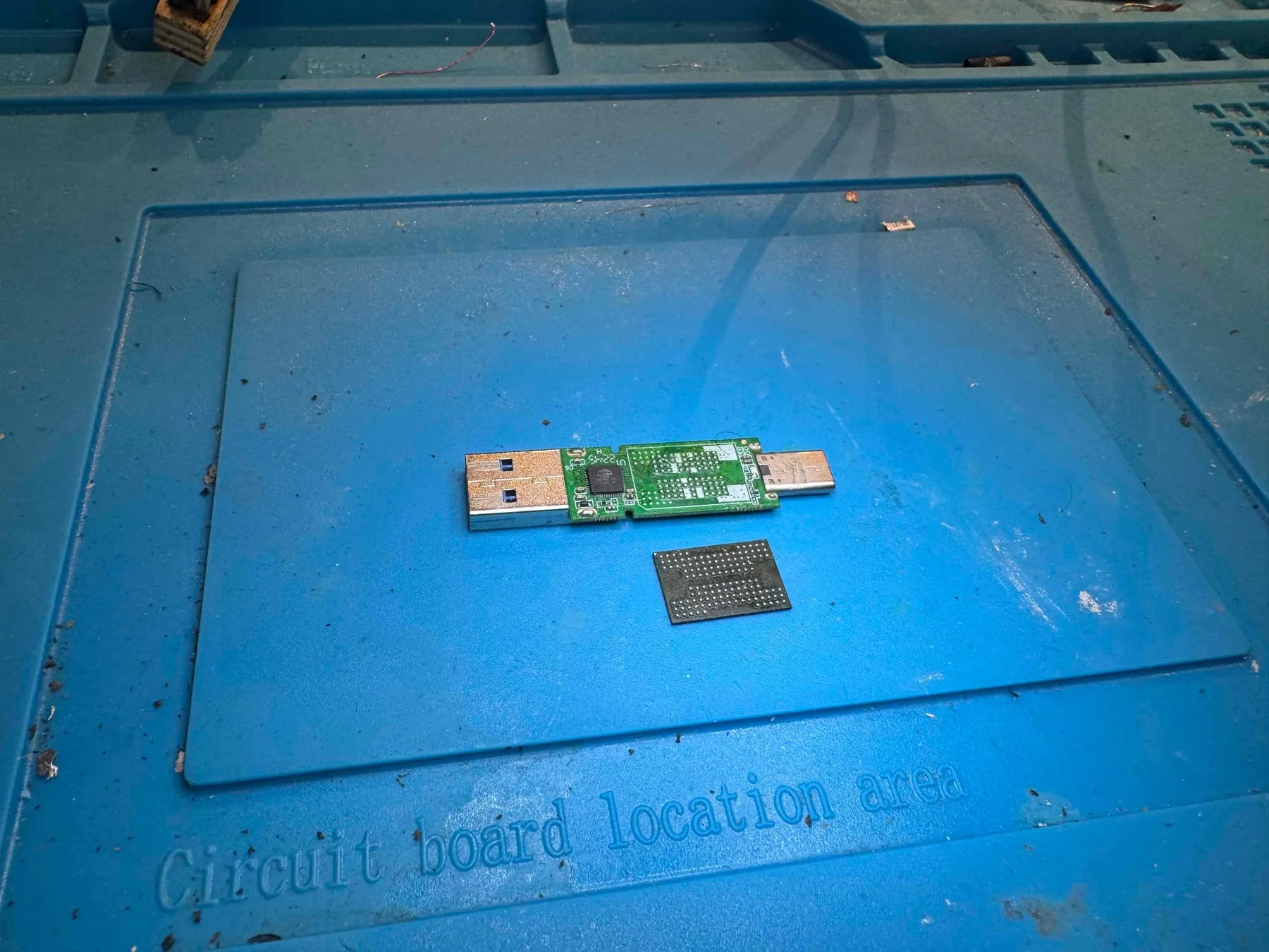 USB flash drive circuit board with its NAND memory chip removed for data recovery